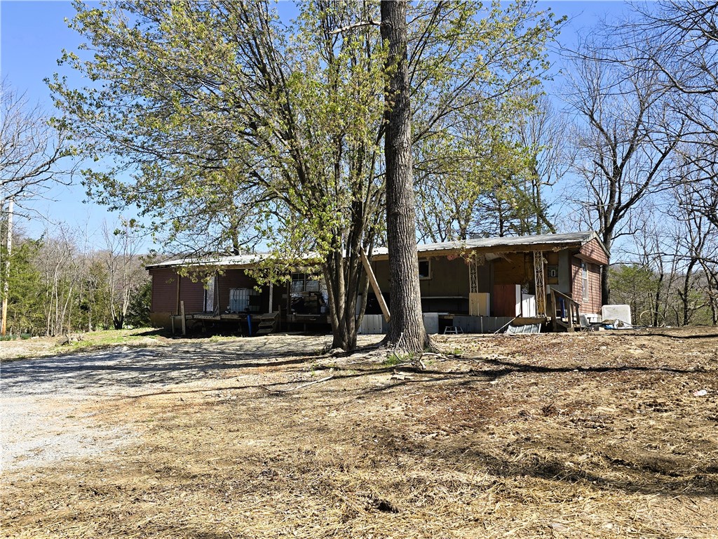 4.63 Acres +/- in an excellent location just outside of Prairie Grove. 5 minutes to Prairie Grove & 2 minutes to the intersection in Hogeye. The property is full of natural stone, hardwood, cedar & wildlife. On the property is a 1,008 sqft manufactured home. House can be finished or torn down to build something new. Electric, city water & septic on site. Mostly wooded with the exception of the current house area. Gorgeous views from the top would make a nice place to build. 15 minute scenic drive to I-49. 20/25 minutes to the U of A. This home will not go FHA/VA/RD. Come check it out.