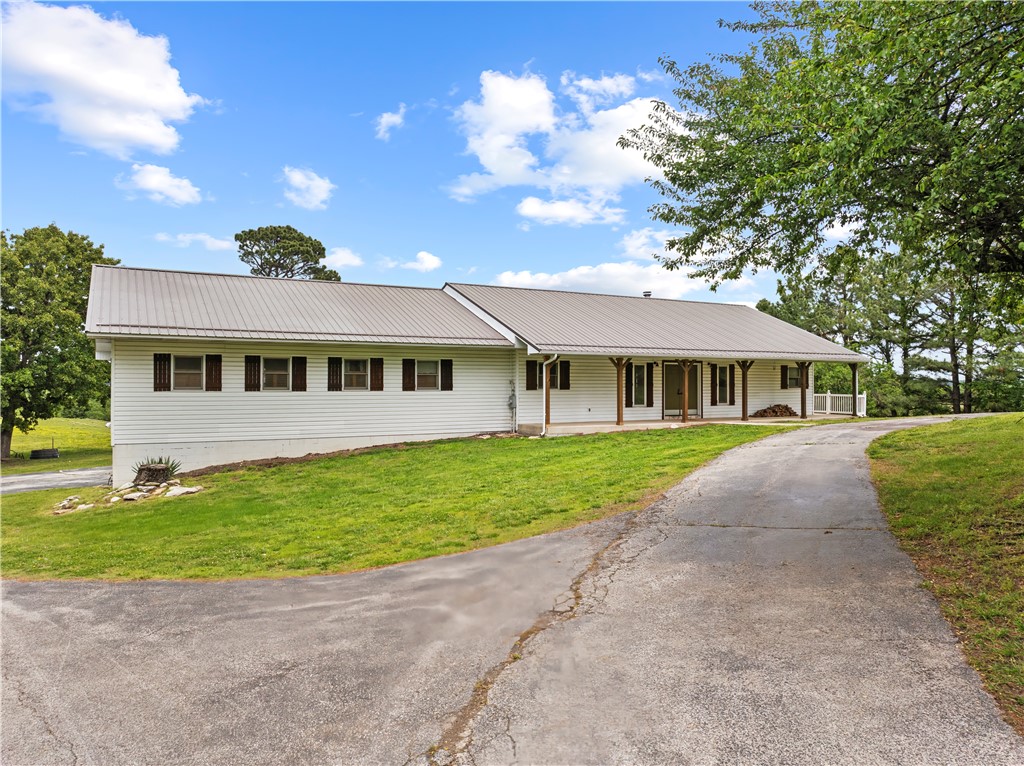 Some properties check the boxes. This one changes your pace.

Set on 37.56 acres of hilltop pasture & scattered woods, this 5-bedroom, 2.5-bath home offers the kind of privacy, views, & open space that’s getting harder to find. The covered back porch stretches the full length of the home, creating the perfect place to slow down, unwind, & take in the scenery. French doors from 4 bedrooms plus the main living area open directly onto the porch, bringing the outdoors into everyday life.

Inside, you’ll find wood ceilings, hardwood floors, oversized living spaces, recently updated full bathrooms, & a stunning 2-sided wood-burning fireplace that adds warmth & character. The property is set up for cattle with a 40x40 barn featuring a 10’ lean-to, a 3-car basement garage, circle drive, & covered front porch that complete the country feel.

Ideal for a hobby farm, ranch setup, hunting retreat, or anyone searching for acreage with usable land, storage, views, & room to spread out.