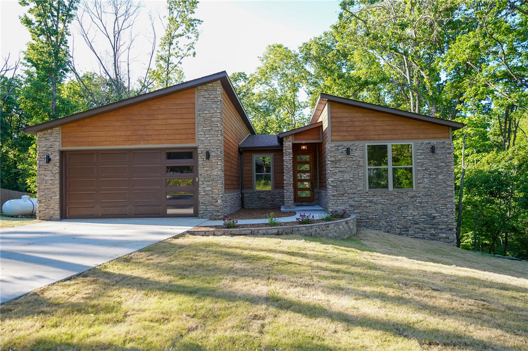Experience the perfect blend of modern sophistication and the peaceful Bella Vista lifestyle in this stunning, newly constructed home. Designed with a thoughtful layout and gorgeous finishes, this property is more than just a house—it’s your gateway to the best of Northwest Arkansas. It features 3 generous bedrooms plus a dedicated office/study, perfect for the remote professional or a quiet library nook. Step out onto your private back deck, ideal for morning coffee or evening BBQs while enjoying the peaceful wooded surroundings. Living here means embracing a community built for recreation. From the world-class mountain bike trails (Lago Vista trail connector only 6 miles away.) to the serene lakes (Loch Lomond Marina 6 miles) and  golf courses (Highlands Golf Club and pub .5 mile) , this home puts you right in the center of it all.