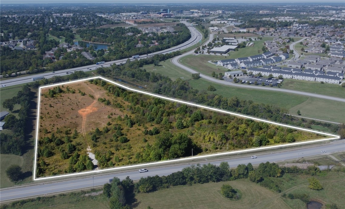 Prime development opportunity in one of Northwest Arkansas’s fastest-growing corridors.
This ±13.93-acre site, offered at $5,900,000 ($423,546 per acre | $9.72 per SF), is ideally
located at the intersection of S 26th Street and Interstate 49 in Rogers—adjacent to A.G.
Russell Knives with 80,000 vehicles per day on I-49. The property features T5.1 zoning,
which allows for a wide mix of uses including commercial, office, and higher-density
residential—promoting walkable, mixed-use development consistent with Rogers’ long-term
urban vision. Positioned less than one mile from Interstate-49 and just one exit (2.0 miles)
from the Pinnacle Hills area, the site is surrounded by a rapidly expanding network of new
residential communities, retail centers, restaurants, and service amenities. With exceptional
accessibility and visibility, this site presents an outstanding opportunity for developers and
investors seeking a dynamic location within the heart of Rogers’ growth corridor.
