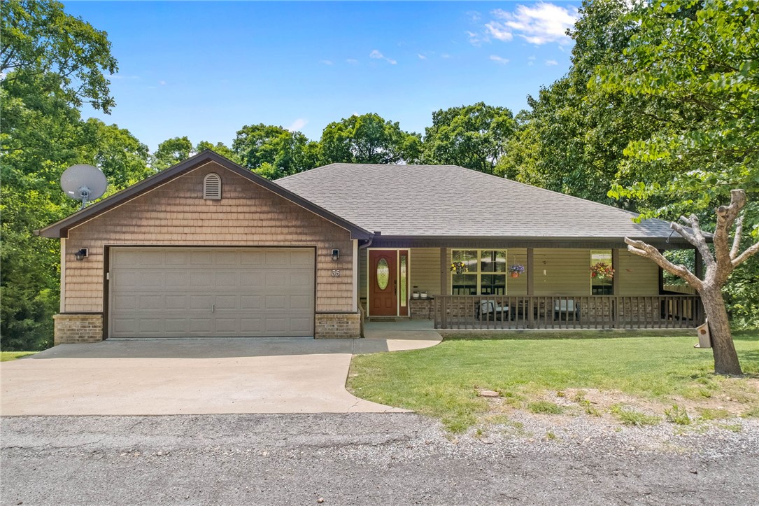 Welcome to this beautifully maintained Bella Vista home tucked away on 2 quiet, wooded lots yet, just a hop, skip and a jump from Back 40 trail access. From the soaring vaulted ceilings and rich wood floors to the warm, open-concept layout, this home feels inviting the moment you walk through the door. The spacious living area centers around a cozy fireplace and flows easily into the kitchen and dining spaces - perfect for everyday living or gathering with family and friends. The kitchen offers abundant cabinetry, stainless appliances and great prep space, while the split floor plan provides privacy for the primary suite. Step outside onto the oversized deck and enjoy the peaceful backyard setting surrounded by nature. This home offers the best of Bella Vista living - just minutes from trails, lakes and amenities.  HVAC new in 2017, Roof new in 2021, Water Heater new in 2019, Deck new in 2022.