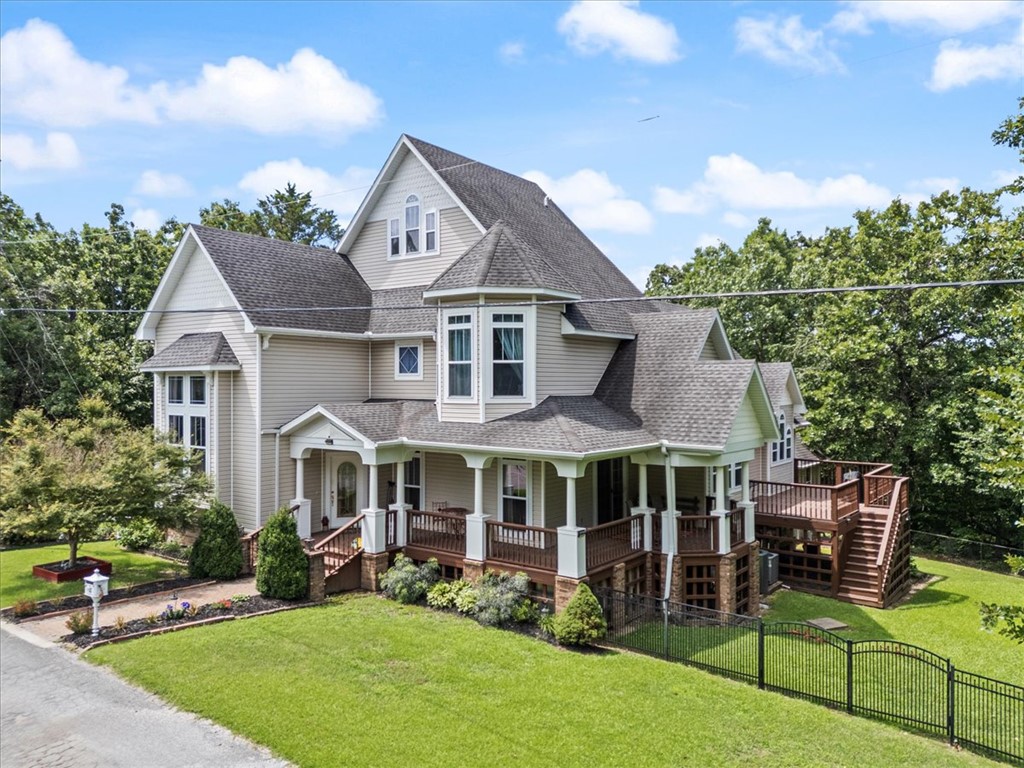 This is a real "WOW" curb appeal Bella Vista home! So much charm! Three stories of wrap around porches, balconies and decks. Over 3,800 SF of living space (not including the 768 SF basement).  A 3 minute drive to the Branchwood Rec Center for swimming, fitness and pickleball.  Four bedrooms and 3.5 baths on three levels.  Living room with wood floors and gas log fireplace.  Large kitchen with TWO islands, prep sink,, pantry and abundant cabinets and counter space.  Open to dining space. Perfect for entertaining.  Spacious primary on main level features a fireplace and oversized walk in closet. Two bedrooms with shared bath on second level. Third level is a private retreat with full bath.  Closet space on all levels is amazing.  Lower level with inside access currently used as second living space with separate storage room. Lots of potential! The wrap around front porch, side porch, deck and private second story balcony add to the charm of this home.  One of a kind!