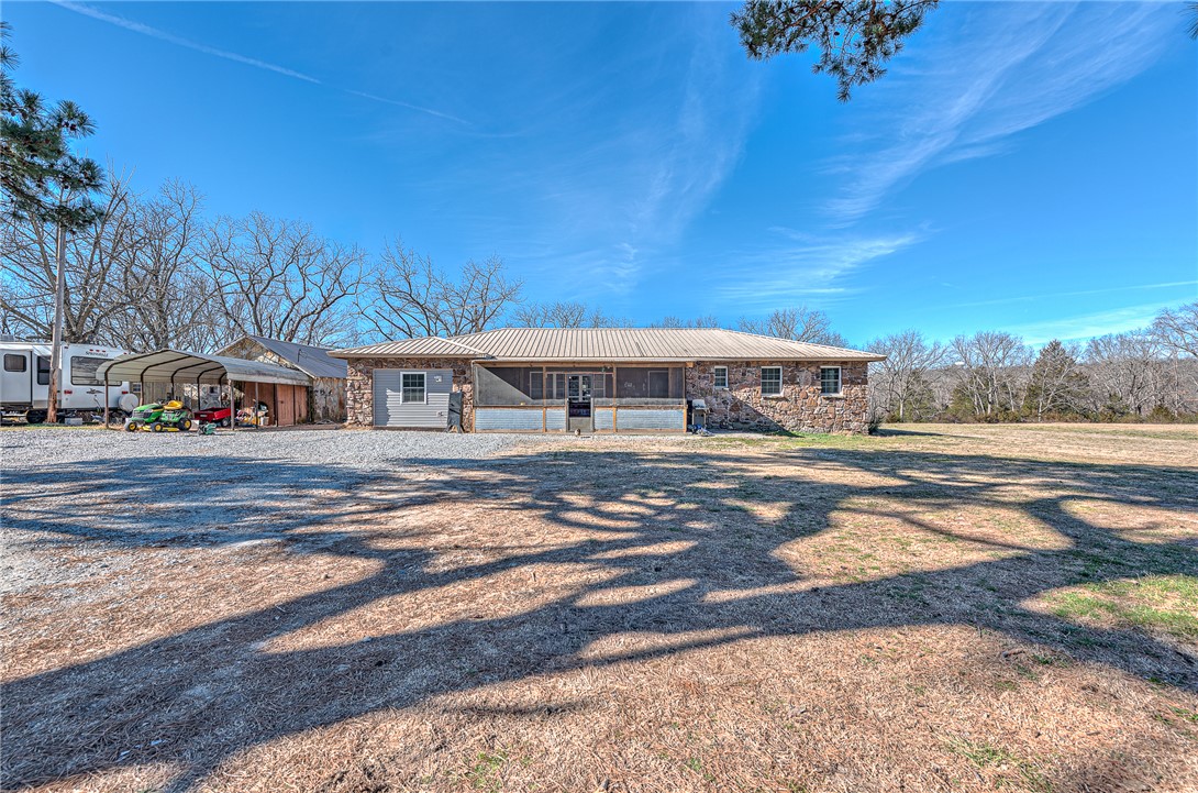 Beautifully renovated 1979 home on a versatile property. Renovated from late 2023 into 2024, nearly the entire home was taken down to the studs with updates including new windows, doors, plumbing, electrical, and central heat & air. Inside features LVP flooring, a gas fireplace, cedar-lined closets, and a wet bar ready for finishing touches. Two bedrooms with paneling and the laundry room were not taken to studs. Property sits on one parcel with 2 addresses. Property also has a 16X64 Mobile home currently being rented for $850 a month. Rock outbuilding includes a 50 AMP RV hookup, and several storage buildings have electricity. Rural water services the home, with a well that could be reconnected. Property featuring a spring, barn with 3 sections, chicken coop, goat pen, storm shelter, and multiple outbuildings. A rare opportunity for country living with room for hobbies, animals, and more.