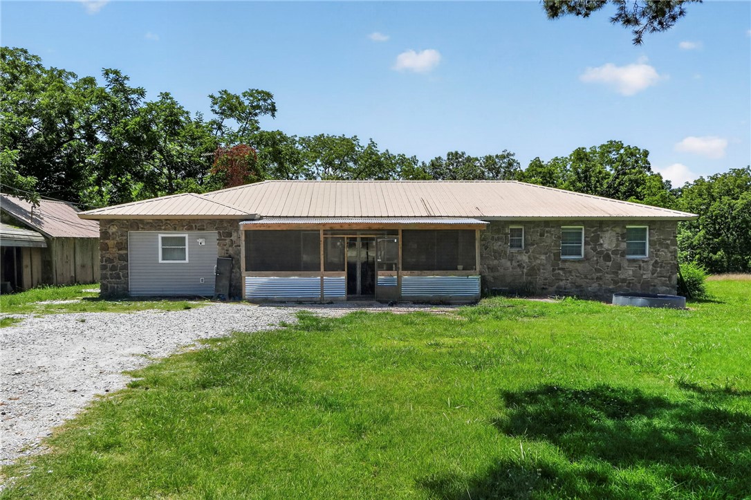 Beautifully renovated 1979 home on a versatile property. Renovated from late 2023 into 2024, nearly the entire home was taken down to the studs with updates including new windows, doors, plumbing, electrical, and central heat & air. Inside features LVP flooring, a gas fireplace, cedar-lined closets, and a wet bar ready for finishing touches. Two bedrooms with paneling and the laundry room were not taken to studs. Property sits on one parcel with 2 addresses. Property also has a 16X64 Mobile home currently being rented for $850 a month. Rock outbuilding includes a 50 AMP RV hookup, and several storage buildings have electricity. Rural water services the home, with a well that could be reconnected. Property featuring a spring, barn with 3 sections, chicken coop, goat pen, storm shelter, and multiple outbuildings. A rare opportunity for country living with room for hobbies, animals, and more.