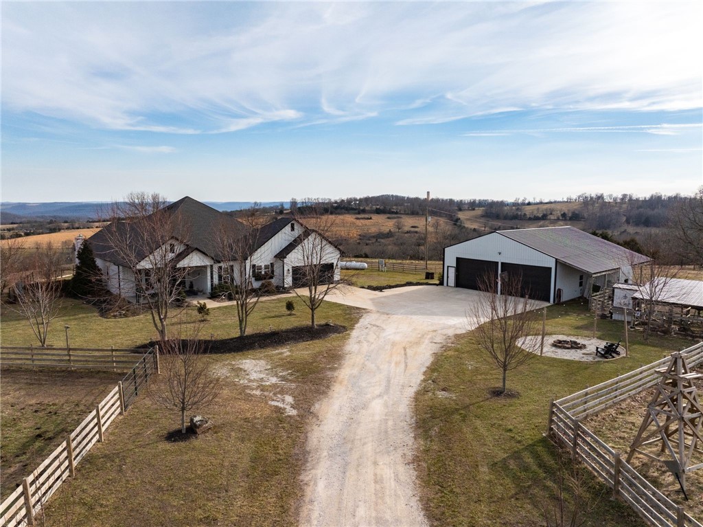 Perched atop a hill in a private, remote setting, this stunning modern farmhouse offers expansive views with unforgettable sunrises and sunsets. Built in 2018, the 3,450 sq ft home features 4 bedrooms and 2.5 baths and includes 20 acres. The kitchen is designed for both beauty and function with granite and butcher block countertops, soft-close cabinetry with custom slide-outs, pantry, farmhouse sink, pot filler, and double oven. The spacious primary suite showcases shiplap accent walls, a large custom tile shower, soaking tub, and a walk-through closet that connects directly to the laundry room. The laundry room includes a sink and abundant storage. Oversized sunroom featuring a gas log fireplace & mini-split system. Outdoor enthusiasts will appreciate the proximity to the Buffalo River and popular hiking destinations including Hemmed-In Hollow, Hawksbill Crag, Lost Valley, & Centerpoint Trailhead. Wired for a generator and has a whole home surge protector. 40x 50 shop building, chicken coop and room for animals.