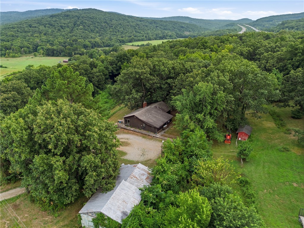 Enjoy peaceful country living on this beautiful 11-acre property just outside West Fork! This 3-bedroom, 2-bath home offers 1,736 sq ft with a desirable split floor plan, pantry, cozy wood-burning stove, central heat and air.  Built with durable wood siding and custom energy-efficient wood-frame window. The roof, HVAC, and water heater are approximately 8 years old. The property offers a blend of open pasture and mature woods along with a pond, making it ideal for recreation, livestock, or a hobby farm. Outbuildings include a 24'x46' detached garage/shop with electricity, barn, fenced side yard for dog run/kennel, chicken coop, and storage building with electric. Stay connected with OzarksGo fiber internet while enjoying the privacy, functionality, and versatility this unique property has to offer.