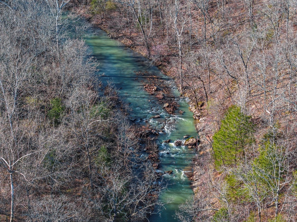 334 untouched acres are a rare find in NW AR and especially when they cradle 1/2 mile of Lee Creek all located only 10 min. from the Ozark Nat Forest, 15 min. from Devil's Den State Park, & 16 min. from the U of A in Fayetteville. As serene as any national park, its beautiful 1920’ elevated mt top entrance along 500 plus ft. of Hwy 170 frontage leads to trails that take you through mt. top views & homesite friendly meadows & beyond through mature trees and dramatic rock outcroppings into the valley. The ½ mi of beautiful Lee Creek works to create its own recreational opportunities in sync with nature. Meander across the creek to discover 2 large meadows where fragments of past inhabitation remain. As recreation areas become more congested, this is an opportunity to invest in your own retreat including 4 plus ponds & a 2nd tributary creek. With electricity & public water plus Ozarks Go Internet, you are invested in the best of access & communication, all within 40 min. of Walmart Headquarters & Crystal Bridges.