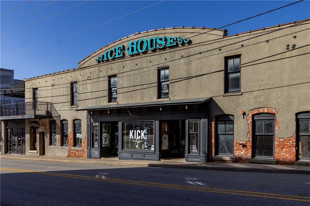 Historic Charm Meets Urban Industrial Vibes in Fayetteville’s Entertainment District! Discover this stylish 2 bed, 2 bath loft condo in the iconic Ice House building, just off Dickson Street in the heart of downtown Fayetteville. This historic cold-storage facility circa 1935, has been thoughtfully converted into modern lofts that perfectly blend preserved industrial character with contemporary living. Step inside to embrace the true industrial loft aesthetic with exposed brick walls, soaring high ceilings, and an open-concept layout that creates a spacious, airy feel perfect for entertaining or relaxing. The grand loft entrance overlooks the living area, offering dramatic views and a sense of volume rarely found in downtown living. Perfect for students, parents or alumni, or as an investment property. Easy access with one deeded parking spot as well as a free parking permit for the entertainment district and guest spaces. Steps away from campus, the Walton Arts Center, and Sorority Row.