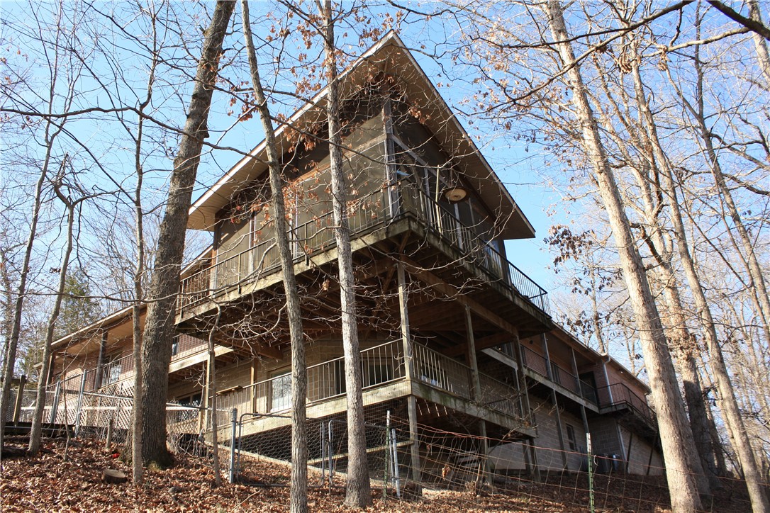 Welcome to your private retreat in the trees! This one-owner, single-family home sits high among the treetops, with stunning lake views from every angle—truly your very own treehouse escape. Enjoy the beauty of nature, from the sights and sounds of the surrounding wildlife to the peaceful rhythm of the water below. Just a few of the many features offered by this property include an upstairs electric fireplace insert, downstairs wood-burning fireplace/wood stove, washer/dryer hookups, whole-house generator hookup, RV parking, 2 outbuilds: woodshed, tractor outbuilding, a beautifully crafted built-in pantry with abundant storage, and a 3-slip dock with one lift. A rare combination of serenity, privacy, and natural beauty combine to make this a must-see property that you’ll need to experience in person to fully appreciate.
