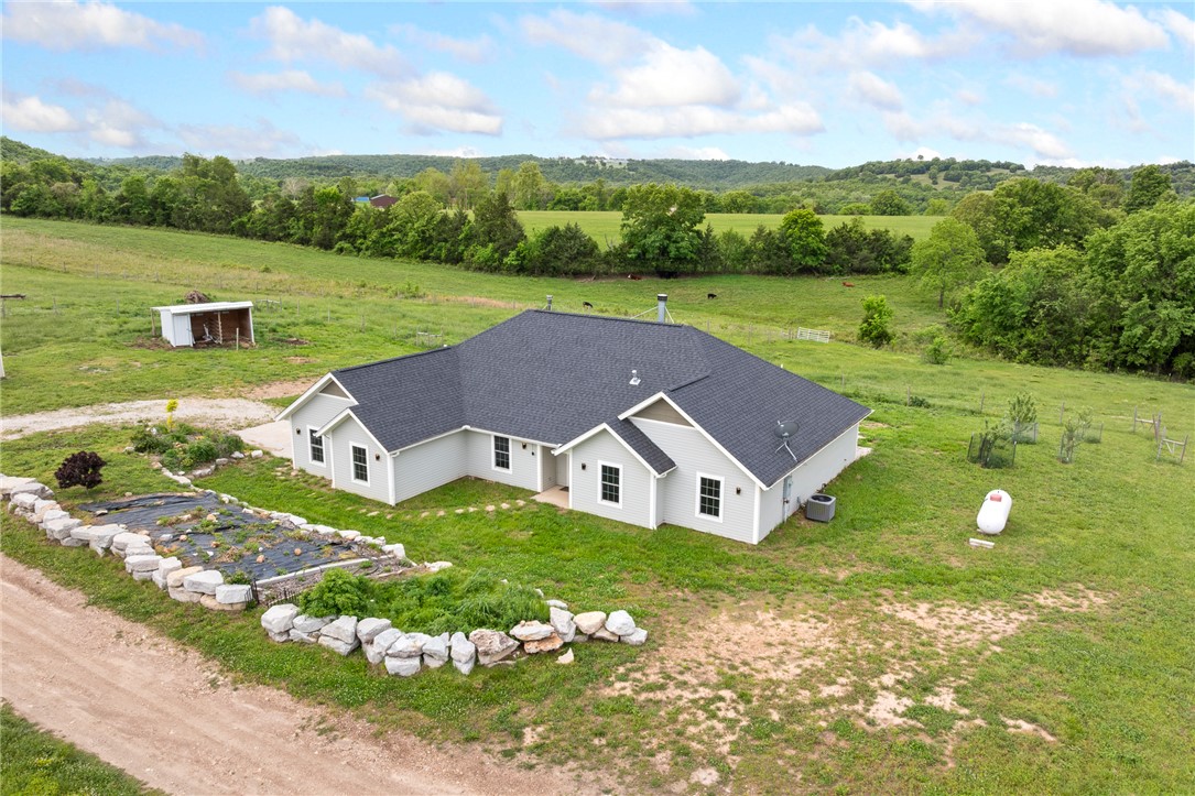 If you’ve been wanting a place to spread out, grow your own food, and live a little more independently, this property is worth a look. Located approximately 12 miles north of Harrison, this 5BR/3.5BA home (2,141 sq ft) with a 2-car garage offers a solid homestead setup. The home features granite countertops, a wood-burning fireplace, and a designated space for a wood stove. Two ensuite bedrooms add flexibility, including one with a large walk-in closet. The land is fully fenced and ready for livestock or gardening, with established apple trees, blueberry plants, a garden area, and a variety of practical, well-established plantings. A shared water well services the home. A 30’x40’ metal shop with concrete floor and electricity provides space for equipment, projects, or storage. Access includes 4.7 miles of dirt road, with the last 1.4 miles being private and more rugged, offering added privacy. Call and schedule your showing today.