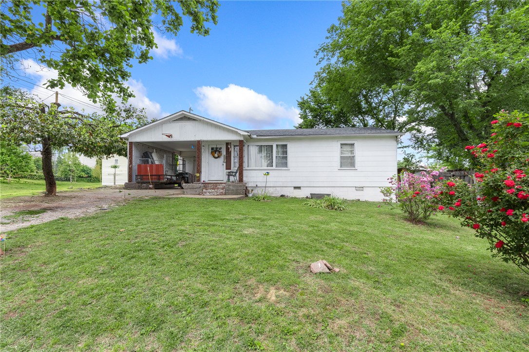 This well-kept, updated 4 bedroom, 2 full bathroom home offers a split bedroom floor plan with plenty of space for everyone. Beautiful hardwood floors run throughout most of the home, new roof installed in 2025 and the gas log fireplace creates a warm and inviting living area. Speaking of the living room, it is so big and you will love all the light that floods the space from the row of big windows!  The kitchen is spacious with a gas range, making it a great place for cooking and gathering. You’ll also appreciate the large utility room with extra storage and workspace.  Outside, the level, corner lot features mature trees and wood privacy fencing, giving you a peaceful backyard setting for kids, pets, or entertaining. The attached covered parking makes everyday life easier by keeping you dry while bringing in groceries or getting the kids inside on rainy days.  Located close to everything; schools, groceries & shopping...this home is move in ready and just waiting on you to say, "YES to this address"!