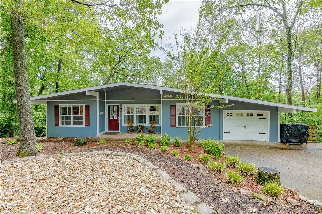Welcome home! This 3 bedroom, 2 bath ranch has been completely renovated from top to bottom.  Nothing left for you to do except move on in! The roof, deck, HVAC, water heater, granite countertops in the kitchen have all been added in the past 3 years. And I haven't even mentioned the real hardwood flooring. Oh, and there's a see-through, wood-burning fireplace, that will provide ambiance in both the Living and Dining Rooms. The kitchen is a perfect place to gather friends and family. There's a one-car garage, but a wide driveway to fit another car. This has all the charm you've been looking for, and at a very affordable price. There are vacant lots on both sides of the home, and nothing but privacy in the backyard.  A balcony deck covers the entire width of the home, and there's a fire pit in the fenced-in backyard for you to enjoy memorable nights. Plus, this is in the Bentonville School District. You've been looking forever...so do yourself and your loved ones a favor, and act fast...this won't last!