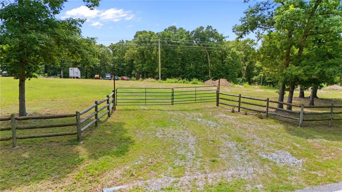 Build your custom home on this beautiful 2.35 acre cleared and gently rolling tract on N Mt. Olive Road in Gravette. Enjoy rural living with major road frontage and no city restrictions. The property offers level build sites, a split rail fence on one side, and flexible mixed use potential. Rural water tap is paid and electric is on site, making your build easier and more cost efficient. With open land, light elevation changes, and no deed restrictions, this is an ideal setting for a modern farmhouse, hobby farm, or private country retreat.