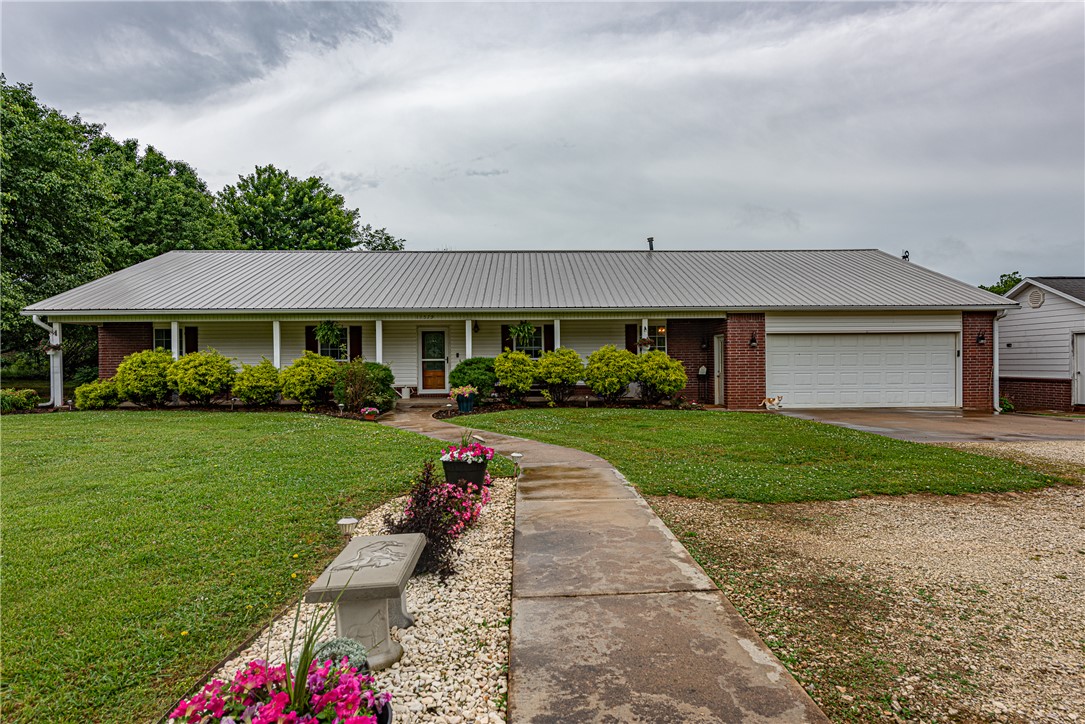 WELCOME HOME! This 4 bed 2 bath home with a bonus or media room on 3.03 acres +/ - is what you've been looking for to plant your roots or start a hobby farm with apple, pear, trees and grapes. Located mins from Downtown Prairie Grove, Lincoln, I-49, & Fayetteville, this property offers a great opportunity for those seeking space while being conveniently located. From the covered porch, head in to the large living area feat wood flooring & French doors providing natural light. Flow into the eat-in kitchen & dining feat black S.S appl, light wood cabinetry, tile flooring! Relax in the primary suite feat a private ensuite w/ dual sink vanity! Enjoy an additional 3 beds and 1 bath! Head to the bonus room  featuring a 285 SQFT  & addtl. storage. Head out back to the covered patio or deck with a hot tub overlooking the back lawn. This property features multiple outbuildings incl. a dairy barn, pole shed, & storm shelter offering versatile use options. BONUS this property features new HVAC 2024! Don’t miss out, act now!
