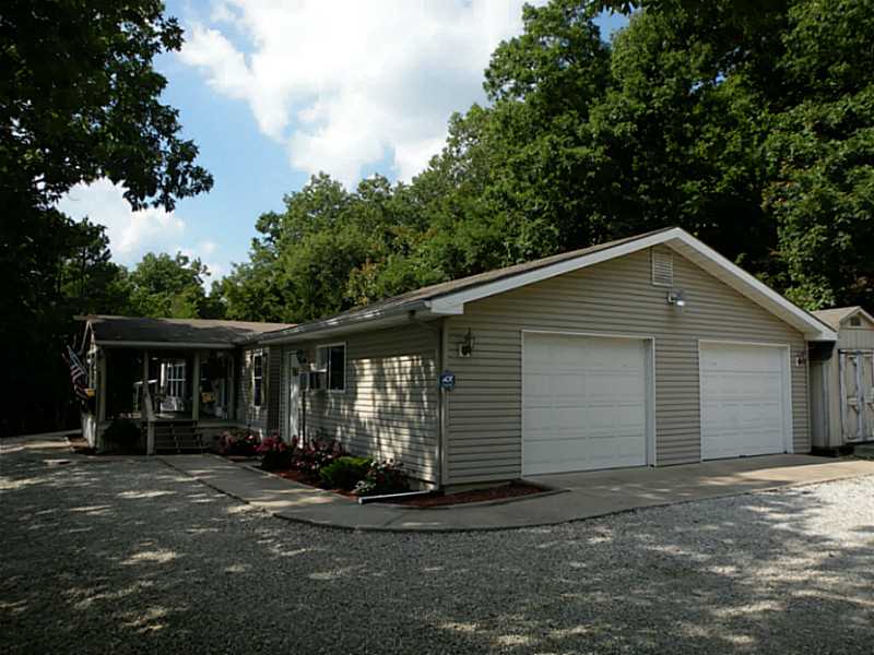 Peaceful setting with nice valley view from the covered front deck & inside the home. Beautiful condition inside & out with an awesome craft and workshop area. Rear deck looks into the woods. Side of home is equipped with a high chain link fenced in area.,Split bedroom floor plan, large kitchen/dining area with breakfast bar and ample cabinetry. The living room has a fireplace & deck.The garage now has attic storage space with shelving, a new art studio area, shop lights and a view from the workshop bench.