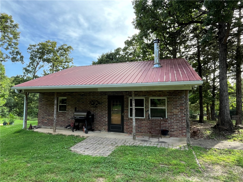 Down a quiet private drive, tucked among tall mature hardwoods stands a little cabin just waiting for you.  Beautiful, private views can be seen from every window with the occasional glimpse of deer and squirrels.  Perfect for a weekend retreat or daily living, this cabin is loaded with character and has everything you need! Step inside to an open plan with vaulted wood ceiling, new kitchen cabinets, one bedroom, two flex rooms that could be office or sleeping space and a bathroom/laundry area with newer walk in shower, cabinets and a bidet toilet.  Refrigerator, washer and dryer to convey. Outside you will find plenty of space for a garden and hobbies with a storage/office/workshop near the house and a large metal workshop complete with tractor and lawnmower!  All contents at closing will convey with property.