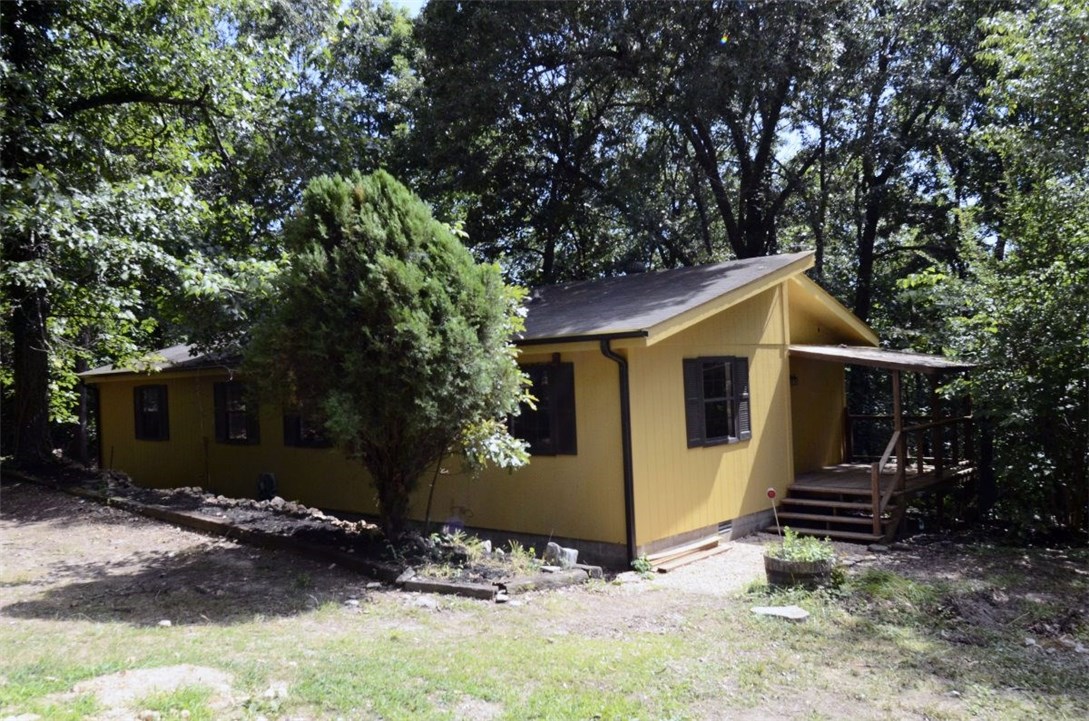 Charming, cottage home in Wedington Woods has been completely remodeled! This 3bd, 1.5ba home sits on over 2 acres & is only 10 min from I49! Brand new, beautiful engineered hw floors have been installed t/o the house w/ tile laid in the ba. The spacious liv features a real wood burning fp & an extra-lg picture window overlooking your beautiful wooded back yard. The flat, landscaped front yard creates a peaceful, well-shaded oasis surrounded by a 6ft privacy fence. Home will be sold as-is.