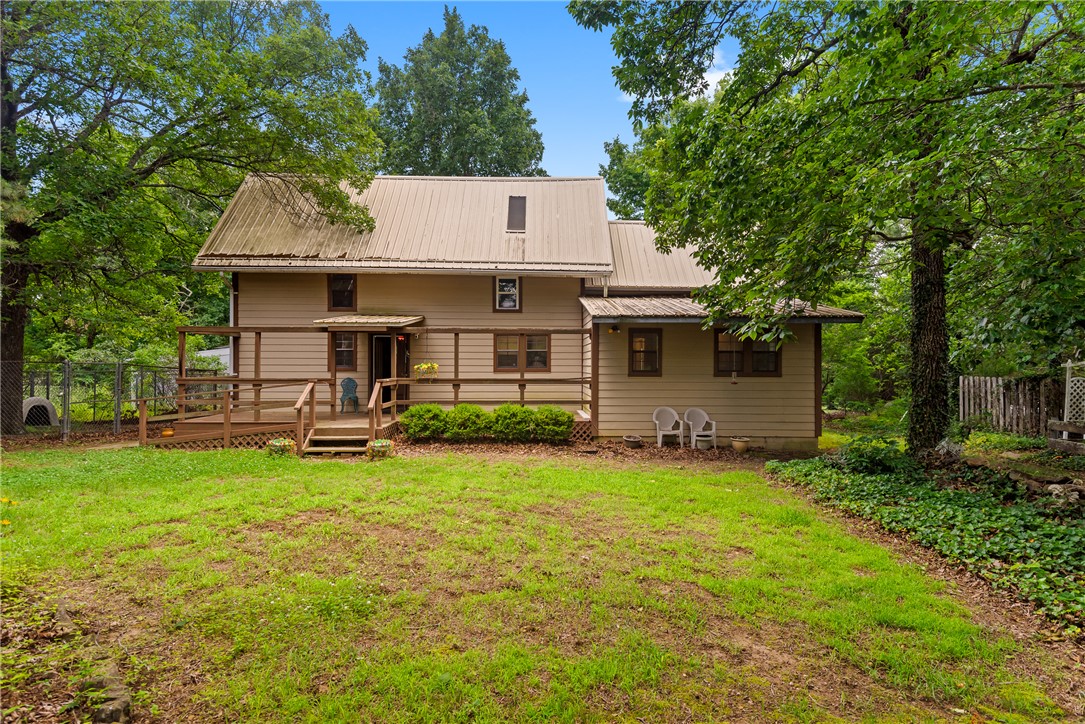 Dreaming of your own private sanctuary in the Ozarks? This 1764 sq ft home on 10 mostly level and beautifully landscaped acres above the Osage River Valley is waiting for you! Vaulted ceilings and an open floor plan with a stone fireplace and wood beams throughout perfectly blend contemporary comfort and rustic cabin vibes. Primary suite has a full attached bath and recessed can lighting. Second bedroom on main level has barn wood style wainscoting and marble window sills. Third level is a loft bedroom with skylight and louvered wood shutters on peek-a-boo windows that open to the den and dining room, with built-in shelving and closets. Separate space could also be used as a home office or reading nook. Lower level den offers a beautiful view of the back yard and with some clearing could be spectacular view of Osage Valley. Detached 2 car garage, large kennel area, and year-round pond on property. Metal roof replaced in 2009 and well pump replaced 2022. Priced so you can truly make this gem in the rough your own!