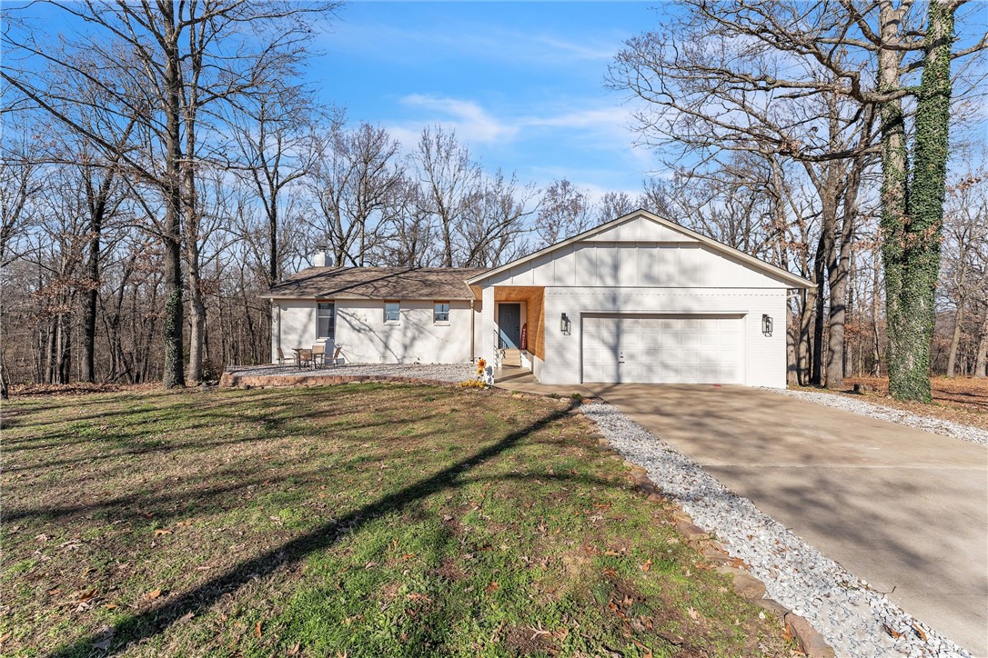 Every corner of this beautifully remodeled 5bd 3ba home has been designed with comfort, functionality & thoughtful details in mind. The eat-in kitchen is complete with SS appliances, concrete countertops, a large butcher block island & coffee bar. Off the kitchen, the spacious living room & dedicated dining area create the perfect setting for gatherings.  Enjoy peaceful views of the serene woods off the new back deck. The fully finished basement offers versatility with a second primary bedroom, complete with a luxurious ensuite featuring an oversized walk-in shower, soaker tub, double vanities, & a large walk-in closet. A second living room downstairs can easily serve as a 5th bedroom, playroom or office, giving your family plenty of flexible space. Additional highlights: full-house water filtration system, a 1200 sqft shop with RV hookup, 220-amp service, full electricity, & concrete floors. This home is ready to welcome your family & friends for years to come. 10 minutes to Beaver Lake & 25 minutes to XNA!