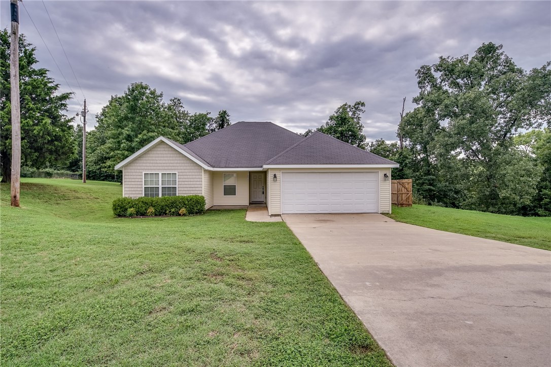 Cute home in Rogers on a large lot and only 2 minutes from Beaver Lake for great fishing. RD eligible. Spacious living room with wood flooring. Kitchen has a nice tiled backsplash, granite counters, pantry, and plenty of cabinet space. Dining room features wood flooring as well. Carpet in bedrooms. Large master bedroom with walk-in closet. Master bath has granite double vanity and another walk in closet! Huge backyard with tons of space for kids to play. Relax under the covered patio or grill out. Property extends past fence-line. Wooded, abundant wildlife. Both the home and the fence line have been power washed to look brand new. New wood floors, new carpet, new paint. This would be a perfect first-time starter home or investment. This won't last long. Come check it out!