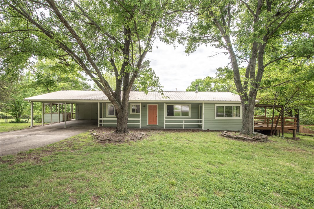 WELCOME HOME! This beautiful  3 bedroom 2 bathroom home  on  0.90 +/- acres located in the town of West Fork minutes away from parks, schools, Hwy 71, and less than 10 miles to Fayetteville! From the covered front porch head inside to the open concept  living area w/ wood floors, wood burning fireplace, & wood beam details! Enjoy a spacious dining area and an L-shaped kitchen with abundant counter space, peninsula for additional seating, & stainless steel range and dishwasher! Relax in the primary suite w/ private ensuite! Wood floors throughout all the bedrooms! Enjoy two additional bedrooms and one additional bath. Head out back to the large partially covered deck overlooking the oversized back lawn. PLUS the exterior of the home has recently been freshly painted. Don’t Miss Out, Act Now!