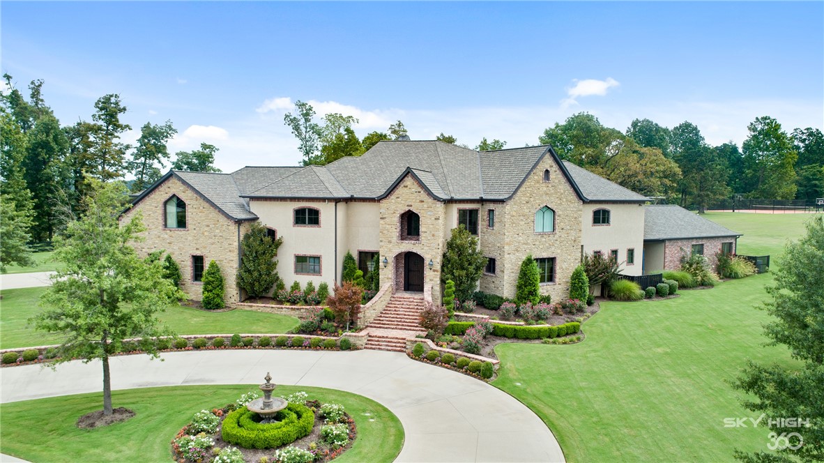 This property will take your breath away! Behind the iron gates, a long maple-lined driveway passes through gorgeous rolling equestrian pastures leading you to the majestic 7,355 sq. ft. estate. Perfectly sited on 43+ acres including 2 barns, a sport court, a custom gunite pool and an incredible pool house. The estate features rich, custom details throughout and modern amenities. The spacious gourmet kitchen is the hub with its large center island and flows seamlessly to the cathedral wood-beam ceiling family room with its floor-to-ceiling fireplace. Featuring 5 bedroom en-suites, a private study, a formal dining room, a wonderful mudroom and a giant recreation room with a built-in playground! This is the perfect getaway, completely private yet centrally located. Total square footage includes pool house 770 square feet.  Bentonville Schools!