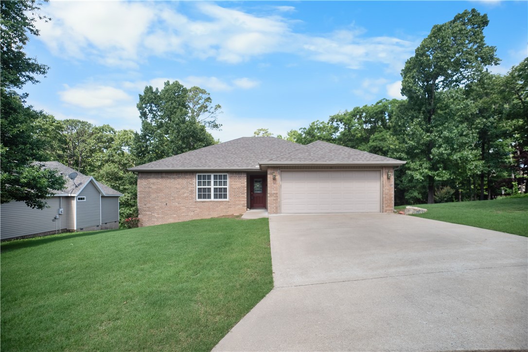 Move-in ready and perfectly located on the desirable east side of Bella Vista! This well-maintained 3-bedroom, 2-bath home offers comfort, functionality, and quick access to Lake Ann and the Back 40 trails. Inside, you’ll find a spacious U-shaped kitchen with abundant cabinet space, bar seating, and updated stainless appliances. The dining area is filled with natural light and flows easily into the cozy living room featuring engineered hardwood flooring and a gas log fireplace. The split floor plan offers privacy, while the primary suite includes double vanities and a walk-in shower. Enjoy outdoor living on the oversized back deck overlooking a large, level backyard with plenty of room to relax, entertain, or play. Additional highlights include a 2-car attached garage, neutral paint tones, and excellent curb appeal. Conveniently located near trails, lakes, golf, shopping, and Bentonville schools, this home is ideal for first-time buyers, downsizers, or anyone looking to enjoy the Bella Vista lifestyle.