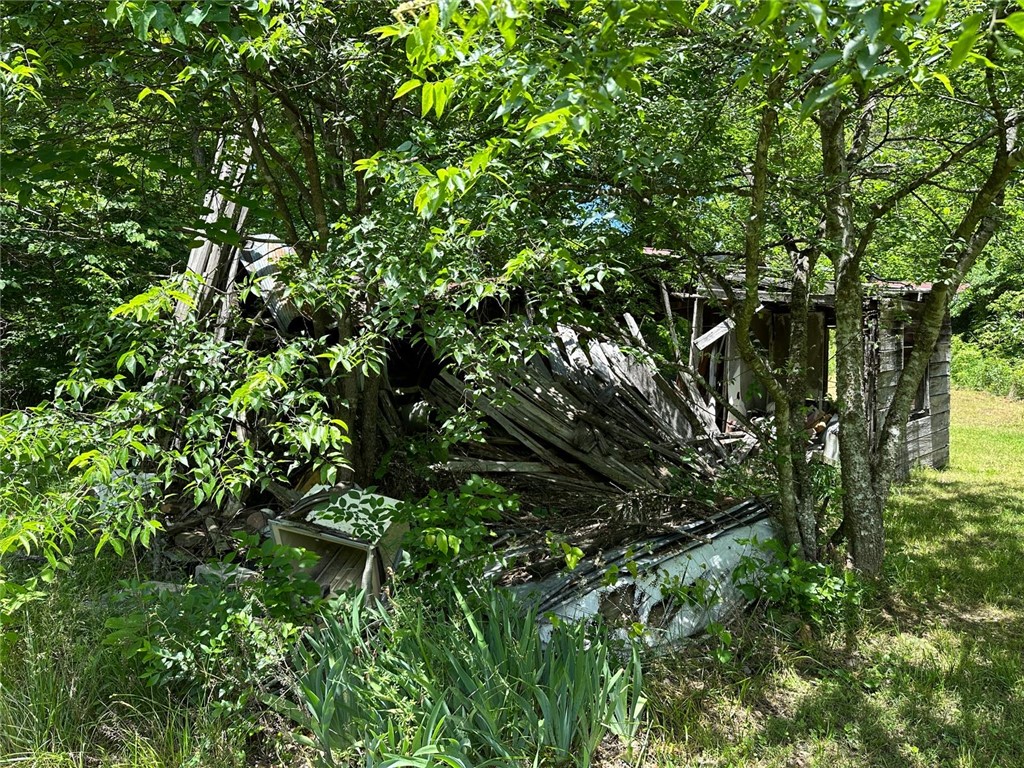 What was standing on land before Arkansas was even a state is still standing today — and it's waiting for the right hands to bring it back to life. This rare 200-year-old log cabin sits on nearly 5 unrestricted acres m/l in the Arkansas Ozarks, bordered by a year-round creek and surrounded by mature hardwoods. Properties like this don't come to market often. Original hand-hewn construction, a living creek, and nearly 5 acres m/l of natural privacy make this one of the more unusual listings you'll find in the region. The cabin is a genuine restoration project — this is not a cosmetic flip. Structural work, systems, and finishes will all need attention. But the bones are historic, the setting is exceptional, and the potential is real. For the right buyer, that combination is exactly the point. The year-round creek is a significant asset. Call today for showings!