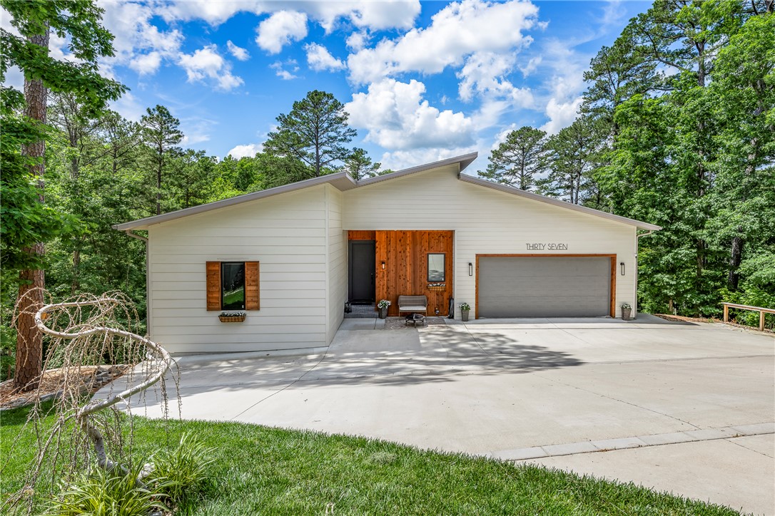 Private wooded retreat with full mother-in-law quarters! This unique 4,357 sq. ft. home is tucked away in a peaceful cul-de-sac with beautiful wooded views and the relaxing sound of a distant creek. Enjoy outdoor living from the oversized wraparound covered deck. Inside features high-quality modern laminate flooring throughout, an open-concept layout, maple cabinetry, marble countertops, center island, and premium 5-star appliances that convey. The main level includes 3 bedrooms and 3.5 baths, including a luxurious primary suite with a cedar sauna, soaking tub, and oversized walk-in shower. Secondary bedrooms share a large walk-in shower with private bath access. The lower level includes a full kitchen, spacious living and entertaining area, 3 bedrooms, 2 baths, private entry, deck access, and closed stairwell—ideal for multigenerational living, guests, or potential rental opportunities. EV outlet in garage.