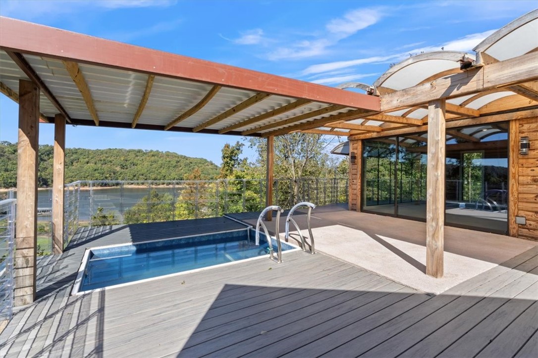 1 year boat lease at War Eagle Marina with acceptable offer! Prepare to enjoy stunning lake views from this beautifully updated 2 BR / 2 BA home on a private 1-acre lot. Modern design meets rustic charm with pine log siding, open-concept living, and 2022-2026 upgrades including newer roof, HVAC, windows, water heaters, kitchen appliances, smart toilets, and additional storage beneath the home. Boat slip at War Eagle is available for transfer. Relax in the 1,500-gallon plunge pool (new pump) overlooking the lake or take advantage of six solar panels powering a backup battery system that runs portions of the home for 2–3 days. Added carport space, privacy, and efficient living make this home truly special. Refrigerator, washer, and dryer convey. Listed below appraisal value—don’t miss this unique lakeside retreat! See adjoining 1 acre property MLS #1335729 Both properties together mls # 1335731