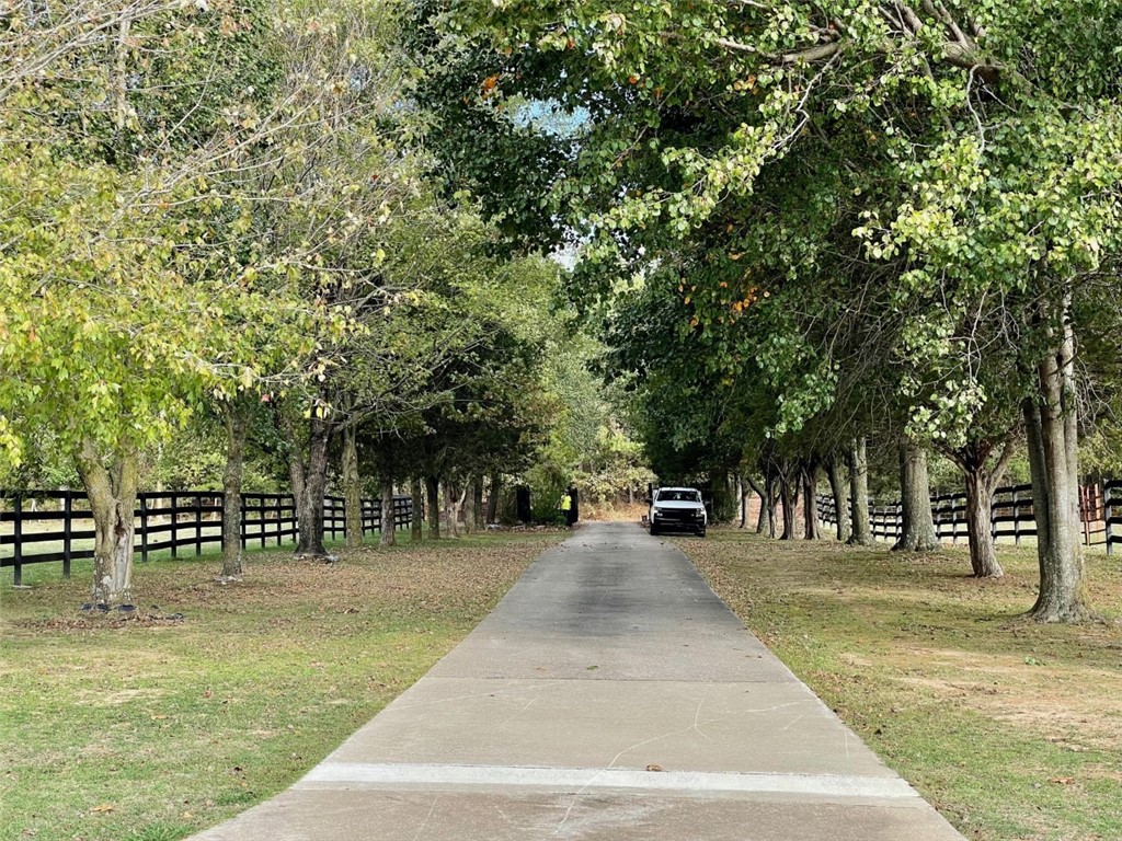 Take the gated, tree lined driveway down to this country estate located just minutes from Fayetteville and Springdale. Home sits on just over 3 acres with amazing views.  Find a 22,000 gallon kidney shaped pool right outside the back door with the same great views. Attached 2.5 car garage with a 5 car carport located across the driveway. Large metal shop building with room for all of your toys. Home has updated granite and stainless kitchen, split floor plan, two offices and two living rooms, a sunken den, and so much storage.  Large utility room and formal dining. Covered front patio is perfect for entertaining.