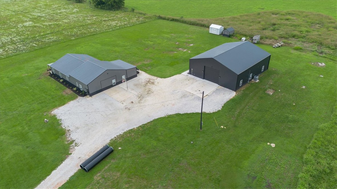 Discover a one-of-a-kind property on 15.73 picturesque acres featuring two exceptional shop houses with a combined 5,800 sq. ft. of heated and cooled living space. The main residence offers 2,800 sq. ft. with 4 bedrooms, 2 baths, and a dedicated office/bar area. The second 3,000 sq. ft. shop includes 1,250 sq. ft. of living quarters with 2 bedrooms and 1 bath, plus a loft, full bar, half bath, fully epoxied floors, and an 18' x 14' insulated garage door. Both buildings feature energy-efficient open-cell spray foam insulation and durable 2x6 exterior walls. Enjoy multiple covered porches, a 12' x 20' covered storage area, and a built-in basketball court. With ample room to build additional homes, this versatile property offers endless possibilities for multi-generational living, business use, or investment. See also MLS# 1353481