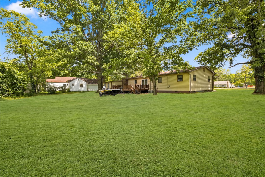 Location, location, location! 10 minutes to U of A and approximately 10 seconds to Lake Sequoyah (depending how fast you can pedal)! Charming 4 bed and 3 bath home in east Fayetteville (with 2 ensuites!); updated and ready as a turn key investment or private residence. Featuring a split floor plan with a newly added primary suite with its own mini split for efficient heating and cooling. With 3 additional bedrooms and 2 more full bathrooms, this home has room for everyone. A large kitchen with a dining space overlooks the large 0.58 acre lot. With two separate living spaces, one featuring a wood burning fireplace, enjoy entertaining and spacious living. An oversized 2 car garage provides convenience and storage. A large, level lot with a wood deck overlooking the massive backyard with mature trees makes this property, ideal for college students, first time home buyers, or a growing family needing more space! Don't miss this opportunity to get into a large, newly renovated home, in premier location!