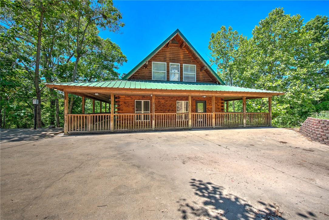 Lakefront retreat on Beaver Lake just 15 minutes from Downtown Rogers dining and entertainment. This distinctive 3 level cabin offers elevated lake living with vaulted ceilings, open-concept design, and expansive wraparound decks on multiple levels for seamless indoor-outdoor living. The upper-level primary suite is a private escape with serene lake views. The lower level features two additional bedrooms, a second living area with wood burning stove, and a bonus room with gun safe ideal for guests or flexible use. A private walking trail leads directly to a 2 slip dock and the clear waters of Beaver Lake, providing rare true lakefront access. Designed for both relaxing and entertaining, this property delivers the ultimate lake lifestyle with space, privacy, and unbeatable proximity to Rogers.