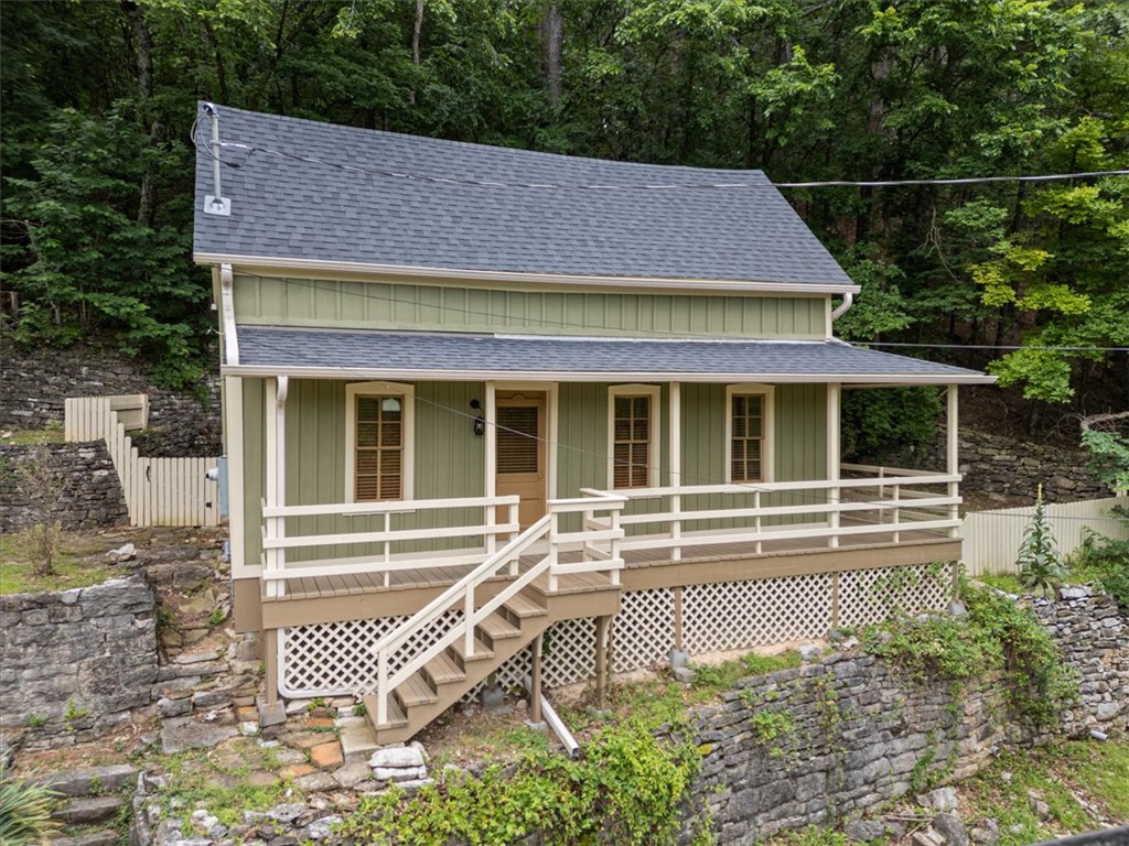 Perched up on East Mountain above historic downtown Eureka Springs, this beautifully restored 1890 cottage feels like something pulled from the pages of a storybook. With views of the iconic Basin Park Hotel and the charm of a Victorian village just outside your door, this is the kind of home people dream about when they imagine living in Eureka. Lovingly taken down to the studs and completely renovated in 2021, this home blends historic character with modern comfort. Skylights fill the interior with natural light, vintage-inspired finishes add warmth and personality, and a flexible bonus space offers the perfect spot for a home office, creative studio, a cozy library. With three coveted off-street parking spaces you can leave the car at home and stroll into downtown Eureka Springs whenever the mood strikes. Because sometimes home isn't just where you live. It's how you live. Invite friends and family for a FUN extended summer stay in your guest house or utilize it as a long term monthly rental for passive income