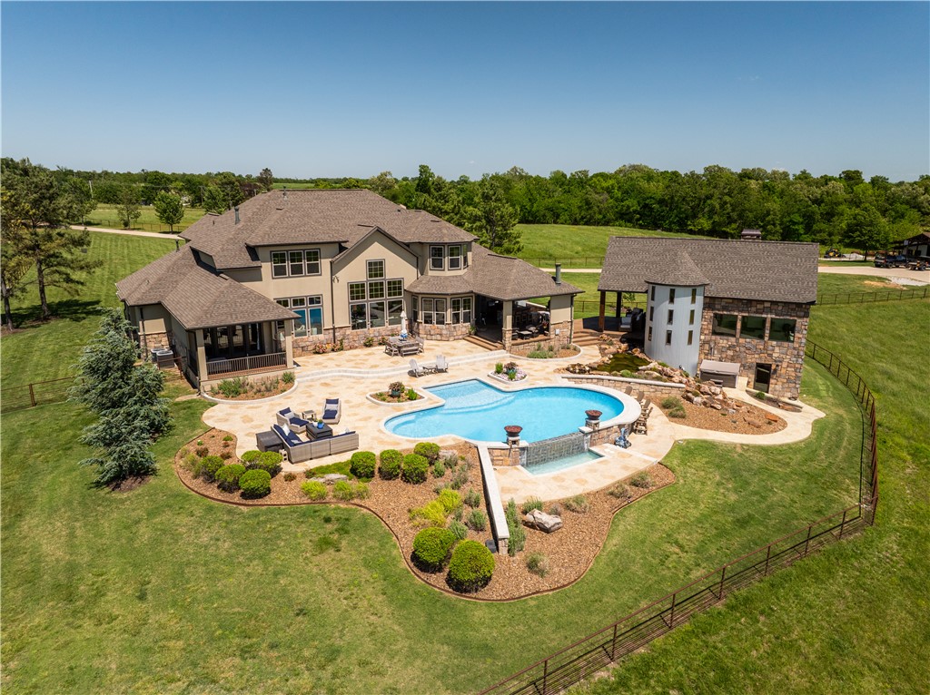 Stunning 40-acre one-of-a-kind equestrian estate with panoramic valley views. Open-concept home features 1BD/1.5BA on the main level w/dual living areas divided by a double-sided fireplace. Chef’s kitchen offers wood cabinetry, granite counters, walk-in pantry, integrated refrigerator, & butler’s pantry. Primary suite includes expansive stone fireplace, heated tile floors, Patina soaking tub, tiled shower & dressing room connected to utility. Office area offers built-in bookcases & views of fields. Upper level boasts living area, utility, & additional 3BD/2BA. 4-car garage with storage & in-ground storm shelter. Modern saloon with Lonesome Dove-inspired bar, loft above, workout room behind & heated patio outside. Below-grade, rock grotto has 1BD/1BA, gathering area & native stone wood fireplace. Outdoor amenities feature a heated gunite infinity-edge pool, koi pond, waterfall & covered outdoor kitchen w/ fireplace. Custom-built barn w/living quarters, stone FP, Priefert panel walker/stalls, storage & lighted arena.