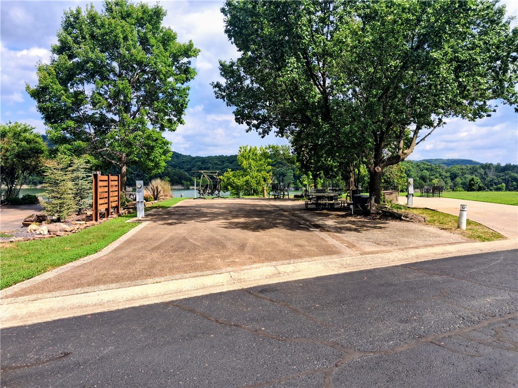 Experience luxury lakeside living at its finest with this premium waterfront RV lot in the highly sought-after Ozark Luxury RV Resort on beautiful Table Rock Lake. Designed specifically for motor coaches, this Pull In lot offers exceptionally breathtaking panoramic water views and unforgettable sunsets from your very own patio. Beautifully landscaped and thoughtfully designed, the lot features an expansive outdoor living space complete with a custom brick-built fire pit, perfect for relaxing evenings with family and friends while enjoying the peaceful lakefront setting. As an added perk, some of the patio furniture conveys with the sale, making this property truly ready for your next lake adventure.