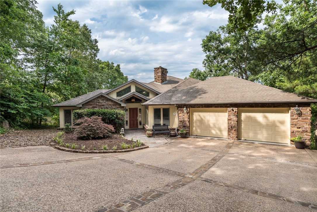 Stunning lakefront home with unique open layout and amazing views throughout. Home features slate flooring throughout main level. Vaulted ceilings w/woods beams.Many large windows. Floor to ceiling stone fireplace. Formal Dining.Office w/built-ins. Spacious open concept between large living room and huge eat-in kitchen. Screened porch sitting in the treetops w/lake views. Master suite is true retreat with lake views,deck access, fireplace & spa-like bath. Huge bonus space downstairs. Tons of storage or workshop space! Private boat dock w/lift.Dog run. This is a MUST see home. Perfect home for entertaining and lake living, plus amazing community amenities.