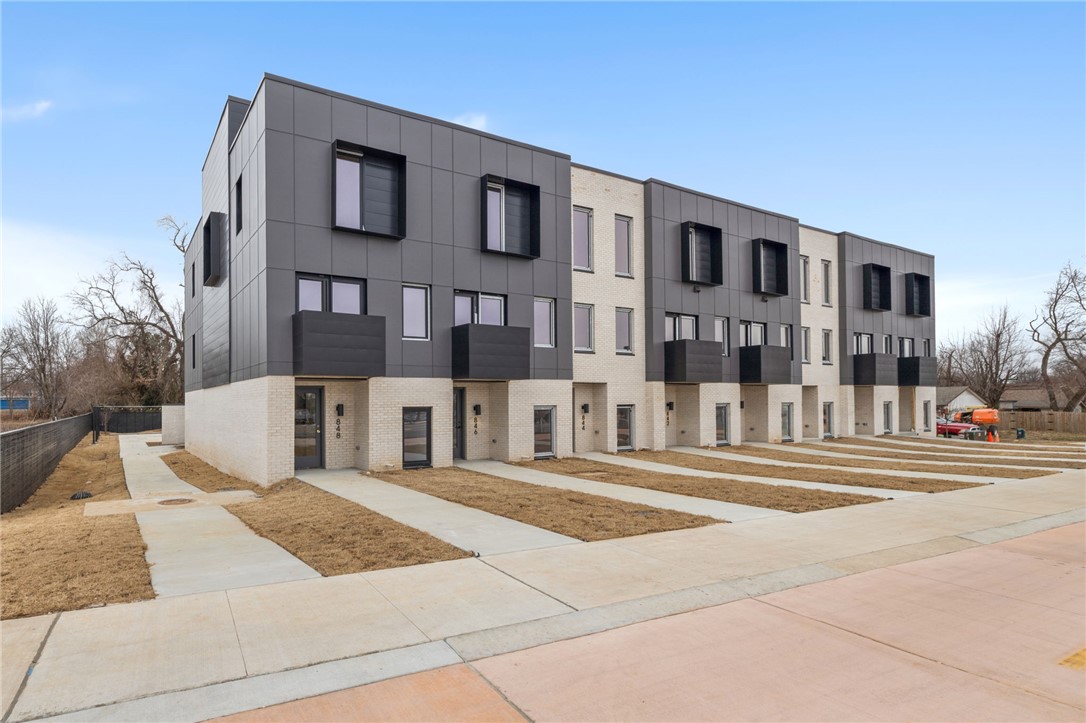 Enjoy the best of downtown Bentonville living in this luxury Lightbox townhome—designed for ones who want walkability, style, and smart design. Located just one block from the new Walmart Home Office campus and directly across from 8th Street Market, this North Light residence offers expansive northern views, including the Momentary. The architecturally striking design allows natural light to pour in from third-floor clerestory windows down through the open stairwell to the main living level, creating a bright, calm, and modern feel throughout. The kitchen blends form and function with a European Bosch appliance package, induction range, white oak cabinetry, and bold quartz countertops. Across the catwalk, the living area is framed by oversized windows—perfect for relaxing or entertaining with a view. Upstairs, two private bedroom suites each feature their own bath, offering flexibility for guests, work-from-home space, or a refined second-home lifestyle—all just steps from Bentonville’s dining, arts, and trails.