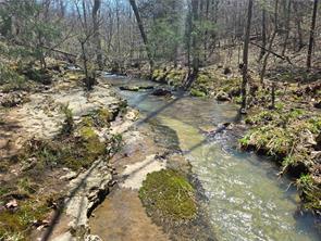 Discover the beauty and serenity of the Ozarks with this stunning 96-acre property nestled in Witter, Arkansas. Located approximately 35 to Fayetteville, 20 to Huntsville, and just under 45min to the breathtaking Buffalo National River. A mix of open pasture and mature woods, the land is fenced on top for livestock and features a year-round, spring-fed creek that adds to its charm and usability. Whether you’re looking for a homestead, hunting retreat, or recreational getaway, this acreage has it all. Wildlife is abundant—white-tailed deer, turkey, and black bear. Making it a paradise for nature lovers and sportsmen alike. An older mobile home sits on-site and has been completely gutted, offering a blank slate for a remodel or easy removal. The existing utilities (water, electric, and septic) are in place, making it easy to build your dream home with an unforgettable view. What a wonderful opportunity to own a diverse and scenic piece of Northwest Arkansas land—don’t miss it! This property is agent owned