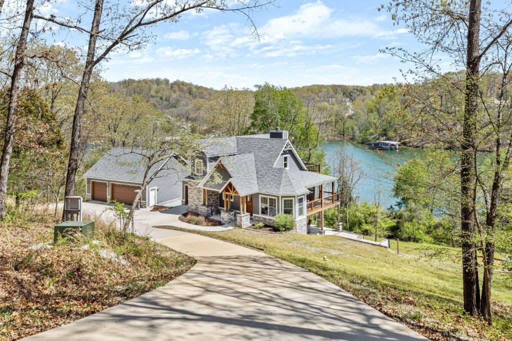LAKE FRONT HOME WITH PRIVATE 1 STAHL DOCK. Stunning custom home with over 200 ft. of shoreline. Easy walk to the dock from back yard. Located on 2 acres, this home captures lake views from most rooms and from ample outdoor covered and open trek decking. High end finishes throughout including saw-milled hardwood flooring, custom ceiling treatments, granite and marble counter tops, custom tile work, and kitchen island built from antique barnwood. Dual heat range with gas cooktop and electric oven. Wood burning insert and outdoor fireplace. Enjoy the lakeside fire pit and hot tub. 3 car garage with an additional golf cart garage. 4 true bedrooms with an additional room and huge walk out basement/game room with kitchenette.