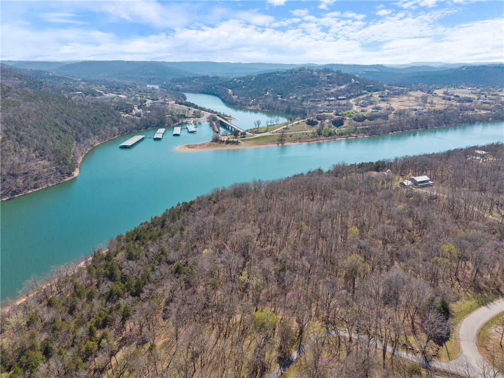 Discover the perfect blend of seclusion and natural beauty with this breathtaking 6.03-acre lakefront property in Oaks Landing, an exclusive subdivision nestled between Table Rock Lake and the Mark Twain National Forest. This pristine lot features two spacious parcels, gently sloping toward the sparkling waters, offering breathtaking views of the lake and the majestic Ozark Mountains with 442 ft of lake front to enjoy. Towering mature hardwoods provide both privacy and a stunning seasonal display of autumn colors and spring blooms. Enjoy easy lake access via the private subdivision-owned swim/fishing dock, or opt for a 28' x 10' boat slip available for purchase at $65,000 via a bill of sale. Whether you're seeking adventure or relaxation, this is your rare opportunity to own a slice of paradise—just 30 minutes from Eureka Springs and under an hour from Branson or Rogers/Bentonville. Schedule your tour today and start building your dream lakefront retreat!