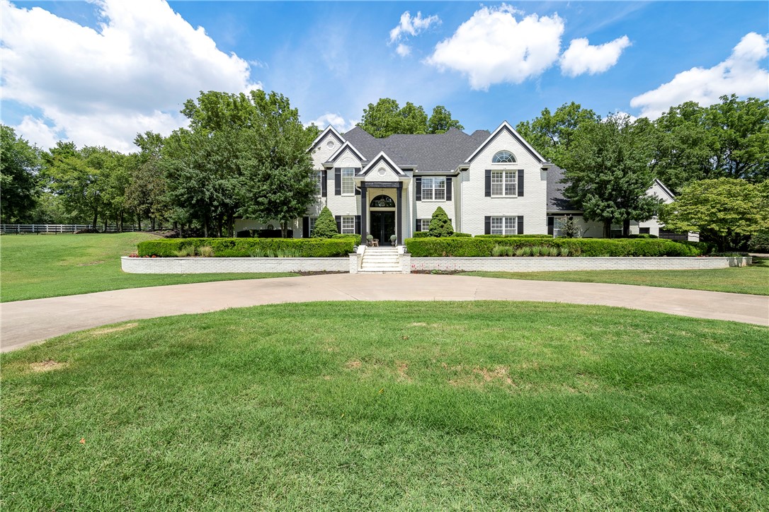 Iron gates welcome you home to this striking Springdale estate conveniently located off HWY 265, near the botanical gardens and Lake Fayetteville. Cross the newly reinforced bridge over Clear Creek to an opening where you’ll find the front steps leading you home. This traditional 1990s home completed a 1 year renovation in 2019 bringing it into modern day style while keeping some of the original charm. Formal living room with a floor to ceiling stone fireplace, grand staircase to the second floor, and an open and airy office. Open floorplan lends itself to entertaining while still feeling casual and comfortable. Bright and functional kitchen, breakfast nook and gorgeous dining room including a stone fireplace. In addition to the formal living room, the downstairs den off the kitchen and upstairs bonus room and theater provide plenty of space for relaxation. Spacious Primary Suite includes a spa-like bathroom and two enormous closets. Outside is an outdoor oasis with a fully landscaped gunite pool, & waterfall spa.