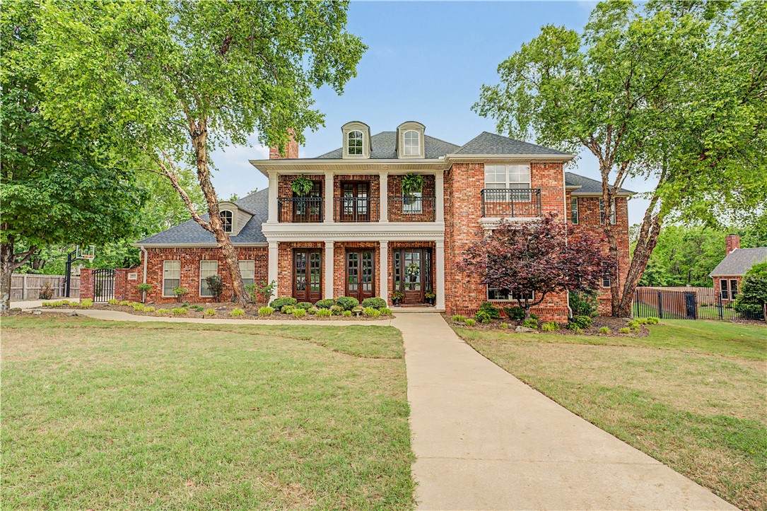 Tucked away on a quiet cul-de-sac in one of Springdale's most desirable neighborhoods, this stunning residence blends timeless southern elegance with unmistakable New Orleans-inspired charm thoughtfully designed living space, this home offers both grand entertaining and intimate everyday comfort. This the home stately presents and signature French Quarter style balcony set the tone for what lies within a space rich in character, warmth, and architectural detail inside soaring ceilings and dramatic 2 story living room create an immediate sense of grandeur, anchored by a striking stacked stone fireplace.  The large windows fill the home with natural light. The kitchen is a true centerpiece -warm, inviting, & full of personality- provides effortless flow to both formal & casual living spaces.  This home is lifestyle with blended design of layered custom touches of southern grace, architectural character, and modern livability in a prime Northwest Arkansas location.  Pride of Ownership!!!