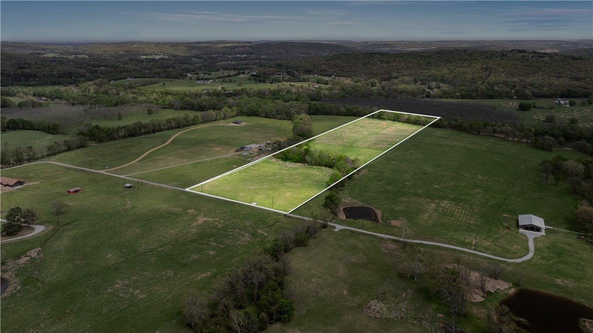 Turnkey 20-acre tract offering a stream, creek frontage, and thoughtfully developed improvements for immediate enjoyment.  Already configured into separate 5-acre and 15-acre parcels, this property is ideal for a multi-generational estate or homestead. The land consists of flat pasture with views toward a mature walnut orchard and Round Mountain ridgelines. The property boundary extends to the center of Richland Creek (tributary of the White River), offering direct access to clear flowing water, fishing, and natural recreation opportunities. Features include a private engineered bridge rated for emergency vehicles, secondary natural rock crossing, underground electric, OzarksGo fiber internet, new 560-foot well, steel carport, four 2-acre rotational grazing paddocks with high-tensile fencing, 12x20 loafing shed with concrete flooring, enclosed storage and livestock manger. Approved perc and septic plans available. No pesticides or herbicides applied for 3+ years, creating potential for organic and regenerative use.