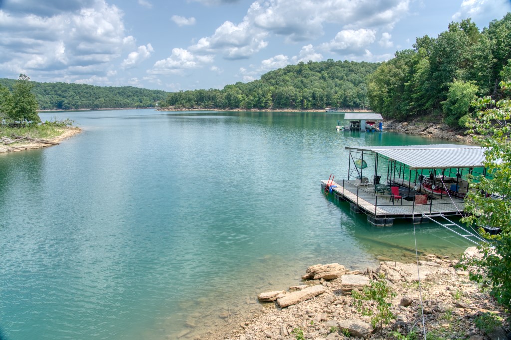 15+ acres with a cabin and a private boat dock! These larger acreages with docks have gotten hard to find but this one is ready for your dream home…or maybe just some weekend fun! This huge private ridge top is a fantastic home site with a great lake view, gradually sloping down to cliffs, boulders, the lake cabin, and then to the private dock. This land is full of fun exploration possibilities! The cabin, built right next to the Corps of Engineers take-line, is just a short, easy walk from the dock! Lots of windows and wood accents give the cabin a very homey and fun feel. This property has just under 400’ of lake frontage that includes the entire back of the cove. It’s easy and quick to get to the main arm of the lake but you will also appreciate the protection, quiet, and clear water this cove provides. Play with friends and family on the 12’x32’ swim platform and store your boats in the 24x8 and 28x10 slips!