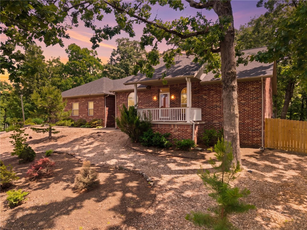 All-brick. Three-car garage, one bay heated and cooled. Two lots. Backed by acres of Bella Vista common property on a dead-end street. Steps away from the Rago bike trail. Inside, newer hardwood floors flow through spaces and a cozy fireplace warming the kitchen, breakfast nook, and living room. The updated kitchen features leathered granite countertops and newer appliances. A formal dining room, home office, and second bedroom sit along the front of the home. The primary suite offers two walk-in closets, a soaking tub, and walk-in shower. The spacious laundry room adds even more cabinetry and a utility sink. A sunroom opens to an expansive composite and wood deck overlooking a yard with mature trees, rock landscaping, and gentle slope with room for an in-ground pool. A whole-home Generac generator self-tests weekly, so you're always ready. Sewer connected. Private, polished, and move-in ready. Hot tub conveys.