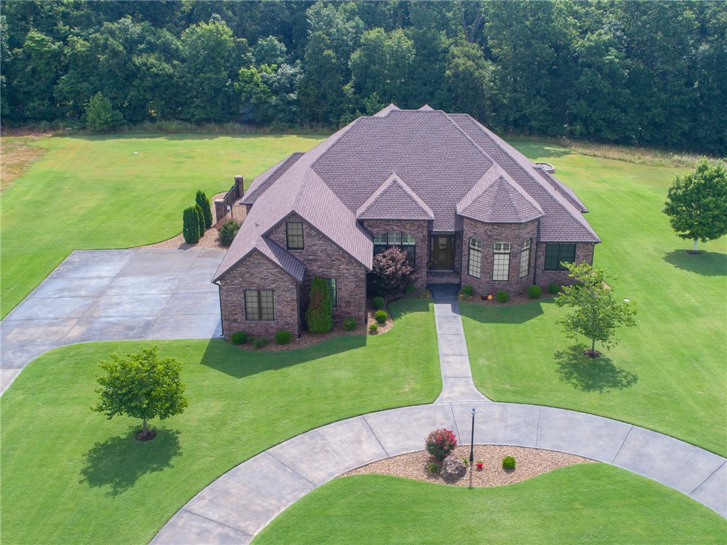 Embark on this Immaculately Maintained FULL Brick Home Situated on 1.27 Acres Surrounded by Nature's Beauty in this Picturesque Subdivision w/ Easy Access to ROGERS & BENTONVILLE! Abundant Custom Features Highlight a Bright & Fresh Open Floor Plan! Gorgeous Hard Wood Floors & Soaring Ceilings help Set the Stage. Maple Cabinetry, Granite Counters Thru-Out. Huge Kitchen Island Perfect for Cooking, Family Time, or Entertaining ~ Truly "The Heart of the Home". Outback find,Screened in Porch & Pool, Iron fence courtyard,