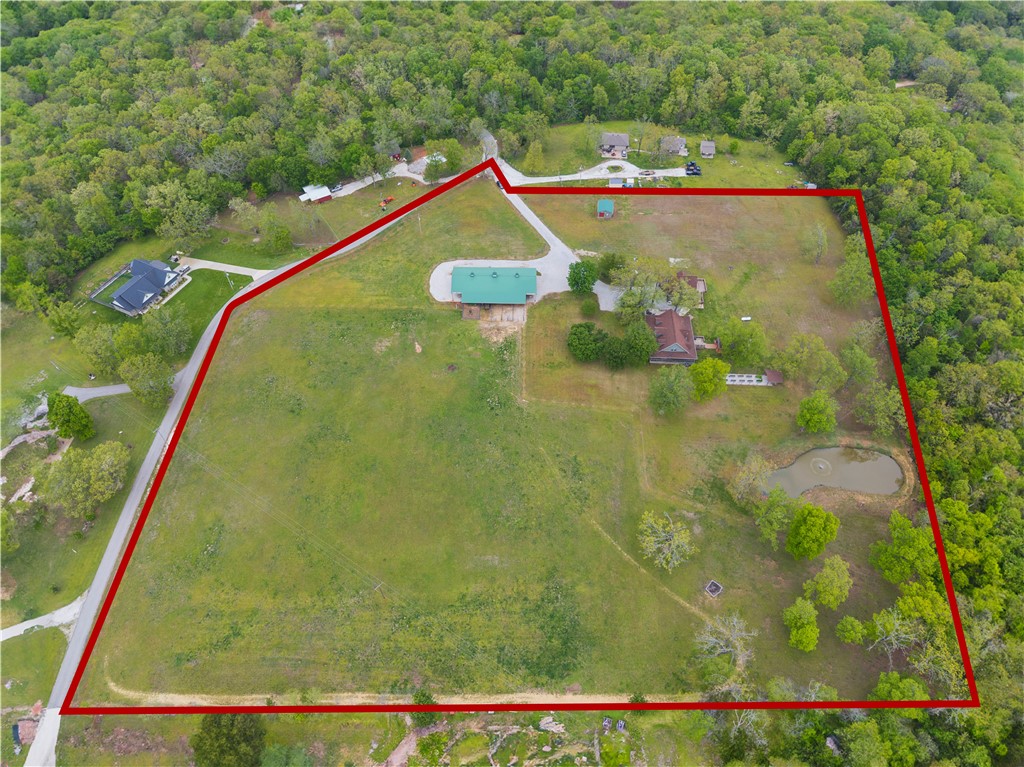 Experience country living in this exceptional +/- 10 acre executive horse property. This beautiful +/- 2,900 SF farmhouse offers a wraparound porch, 3beds/2.5baths, and a luxurious primary suite with spa bath, dual walk-in closets, oversized walk-in shower, and jacuzzi tub. The open main level showcases a remodeled chef's kitchen with granite counters, 4-burner cooktop, large island, custom cabinetry, and wood-burning fireplace. Enjoy peace of mind with a whole-home Generac generator, owned 500-gal propane tank, LeafFilter gutters, and separate HVAC systems. An oversized two-car garage includes a 20'x30' media room with wet bar and mini-split system. Outdoors, entertain in the covered gazebo with stone fireplace and grill, fish in the stocked pond, or work in the she shed equipped with commercial kitchen. Equestrian amenities include a +/- 5,500 SF barn with stalls, wash bay, tack room, shop space, fenced pastures, chicken coop, and raised-bed garden. Luxury, function, and freedom in one extraordinary property!