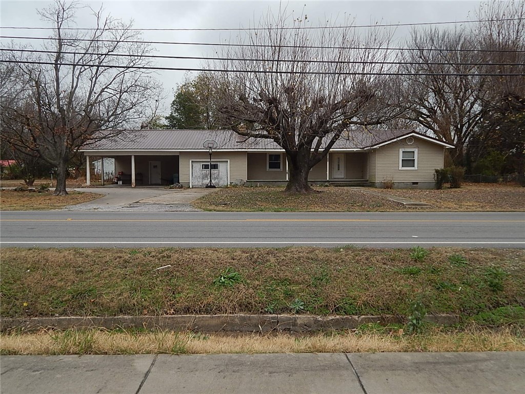 Large home with extra lot with access to street in back and separate metal workshop/garage.  Most floors hardwood-carpets just removed, newer oak cabinets in kitchen, huge utility room, attached workshop, bathroom extra large, half bath wood lined, has central heat and a/c, attic fan, tons of potential for someone who wants to do some updating.  Area is near everything and exterior roof and siding looks pretty good.  Formal dining, 2 car carport plus 1 car garage (needs new door).  Loads of potential.